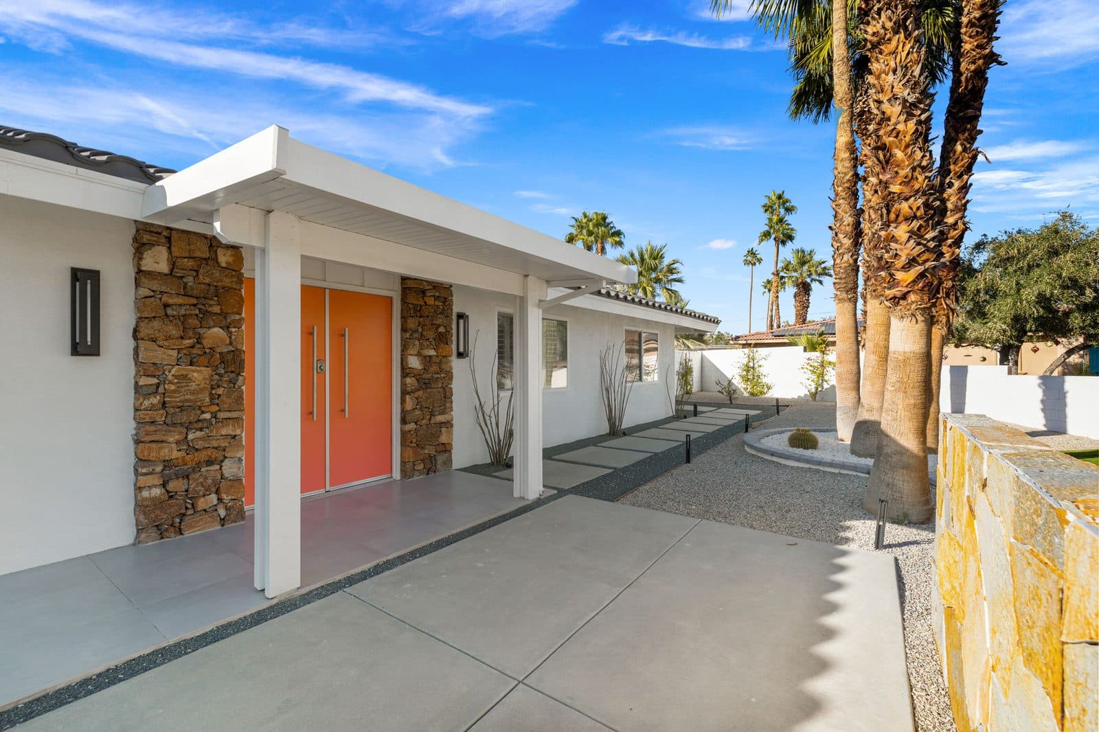 Orange double doors and stacked stone entry