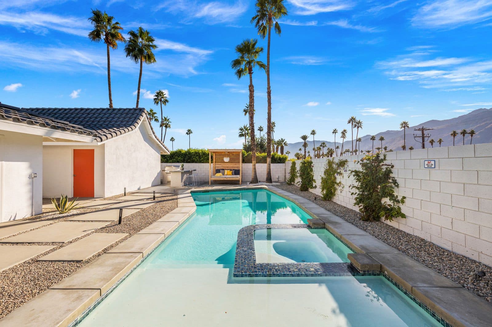 Long pool and hot tub under blue skies
